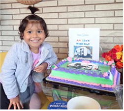 Amelia next to her birthday cake smiling for the camera