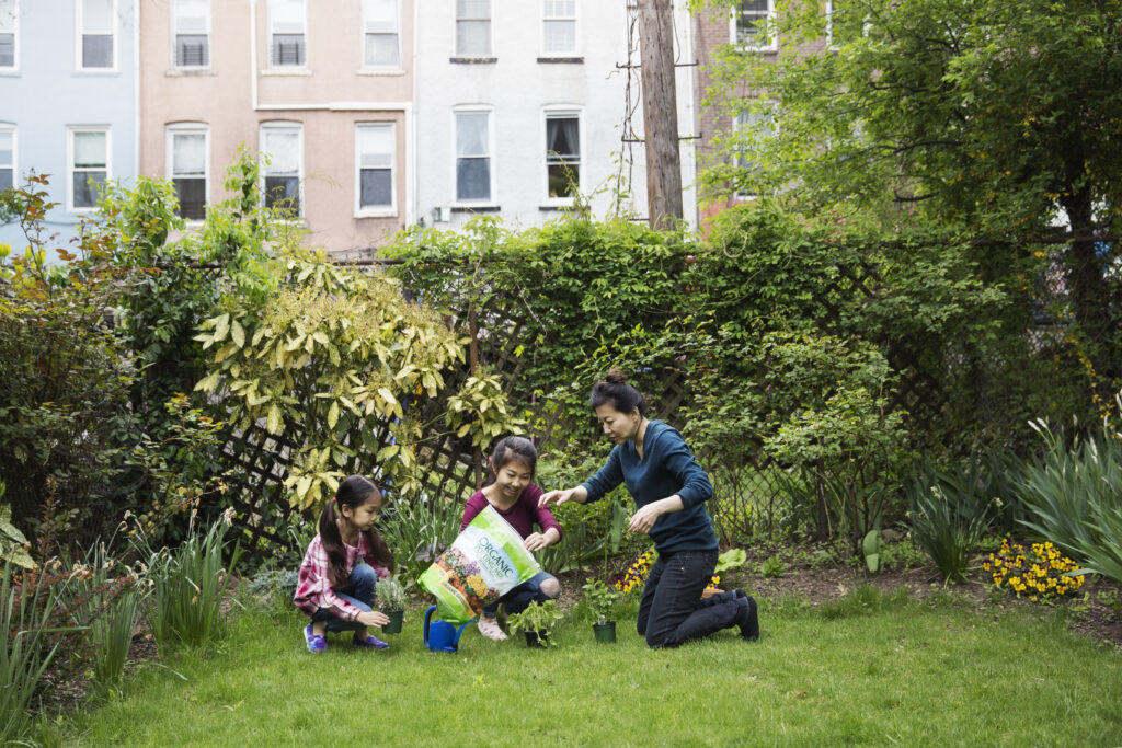 Family Gardening in their Yard Against Building